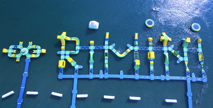 'alto, ha la forma della parola Rimini, con tanti giochi e divertimenti per la vacanza in famiglia, con uno spazio dedicato ai bambini al quale possono accedere accompagnati da un adulto. Aquapark Boabay per le vacanze in famiglia a Rimini vista dall'alto della struttura dove si vede la forma caratteristica del complesso.